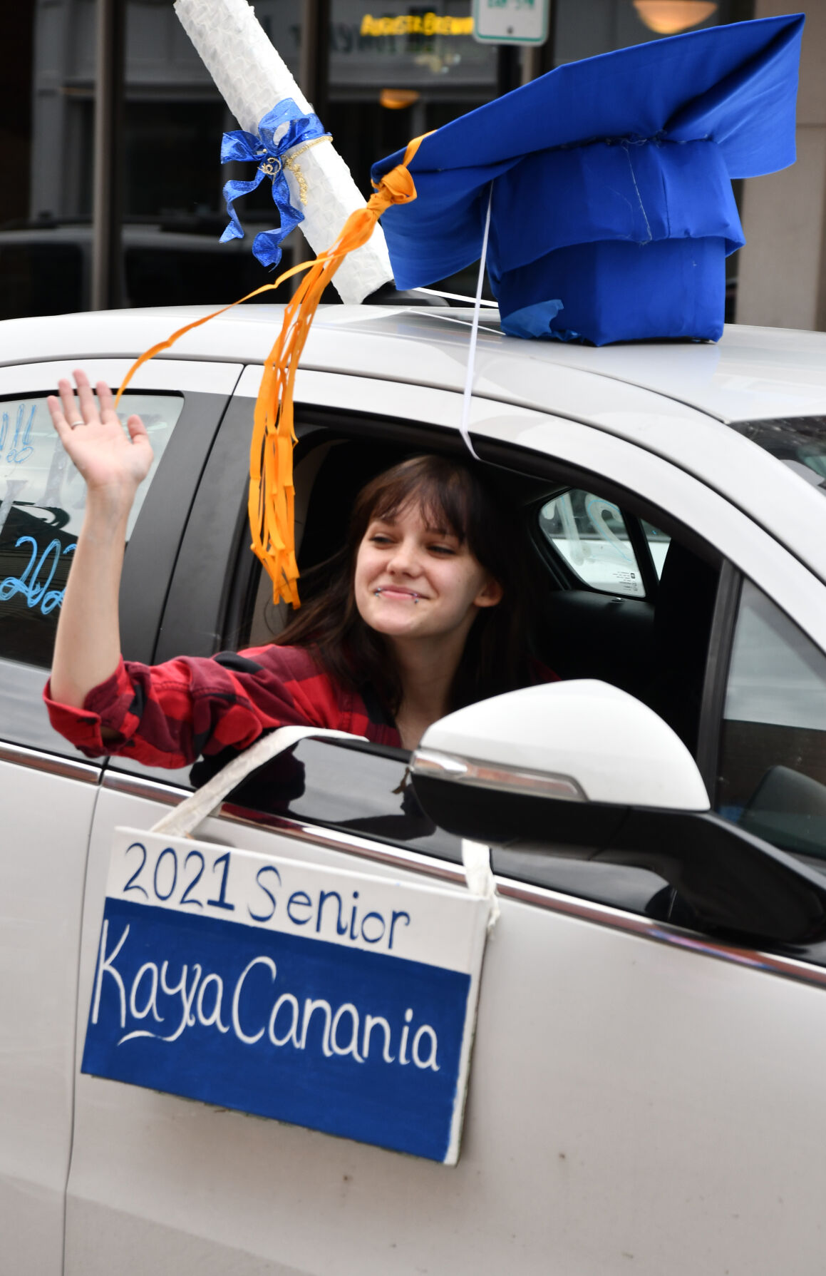 Kaya Canania waves out a window